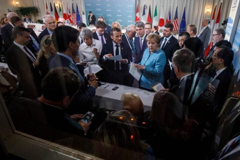 Canada's Prime Minister Justin Trudeau and G7 leaders Britain's Prime Minister Theresa May, France's President Emmanuel Macron, Germany's Chancellor Angela Merkel, President Donald Trump discuss the joint statement following a breakfast meeting on the second day of the G7 meeting in Charlevoix city of La Malbaie, Quebec.