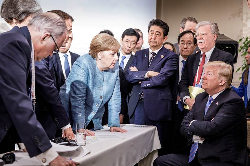 G7 Summit 2018: Donald Trump has felt the diplomatic heat during G7 Summit 2018 in Canada when global leaders purportedly confronted the US President. Leading the charge German Chancellor Angela Merkel is seen at the forefront looking at Trump assertively with arms planted on a table, as the US president sits with his arms folded as world leaders surrounded them. The iconic photo, which has gone viral, was captured by German government photographer Jesco Denzel and released by Merkel's spokesman Steffen Seibert, according to reports.