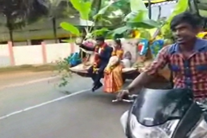 A newlywed couple in Karnataka went home on a JCB machine after the ceremony. ( source: video grab) A newlywed couple in Karnataka went home on a JCB machine after the ceremony. ( source: video grab)