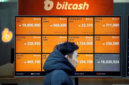 A man walks past an electric board showing exchange rates of various cryptocurrencies including Bitcoin (top L) at a cryptocurrencies exchange in Seoul, South Korea December 13, 2017. REUTERS/Kim Hong-Ji
