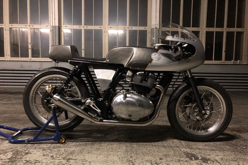 While the concept is pure cafe racer - referencing the iconic Rickman's fairings - the build has a hidden surprise. In the dark, a layer of reflective paint transforms the classic lines into a riot of Razzle Dazzle light.