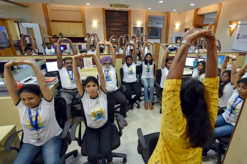 Yoga in Office: Employees of an organisation participate in a yoga session on the eve of International Yoga Day, in Mumbai on Wednesday, June 20, 2018. (PTI Photo)