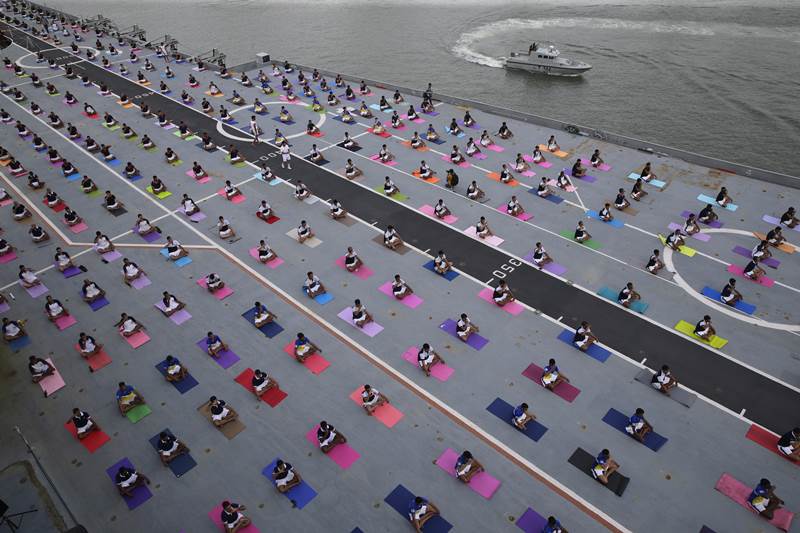 Defence personnel perform yoga on the deck of Indian naval aircraft carrier INS Viraat as they mark International Yoga Day in Mumbai, India, Thursday, June 21, 2018. Millions of yoga enthusiasts across the world Thursday took part in mass yoga events to mark International Yoga Day. (AP Photo)