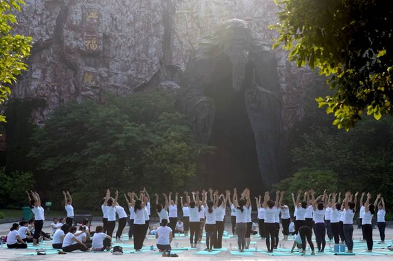 Yoga Day mania grips China: People practise yoga on International Yoga Day in front of a giant Laozi statue at Bochishan Park in Huaian, Jiangsu province, China. (Reuters image)