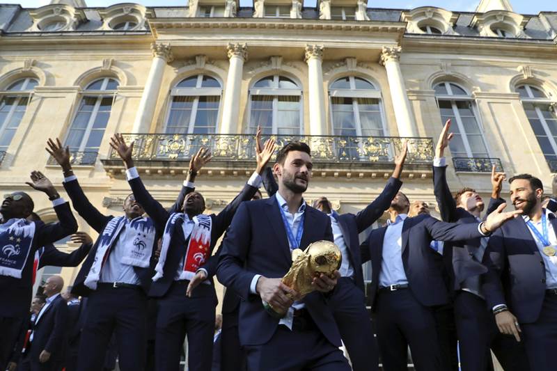 France goalkeeper Hugo Lloris holds the World Cup trophy during an official reception at the Elysee Presidential Palace in Paris. Millions of fans in France celebrated into the night, honking car horns and flying the tricolour flag while the Eiffel Tower and the Arc de Triomphe were lit up in the national colours of blue, white and red.