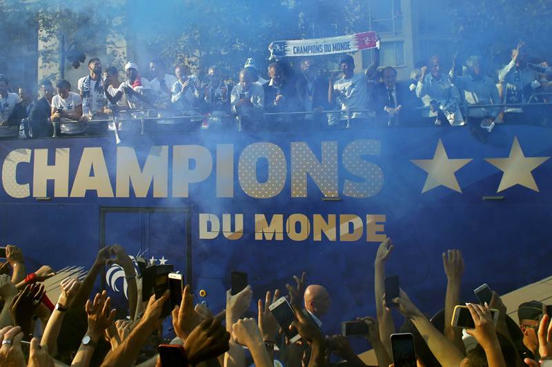 France's victorious World Cup team descends in a bus upon Paris' packed Champs-Elysees avenue. The players arrived at a raucous welcome at Charles De Gaulle airport northeast of Paris, including a "water salute" by the fire brigade which sprayed arcs of water over the Air France jet as it taxied to the gate.
