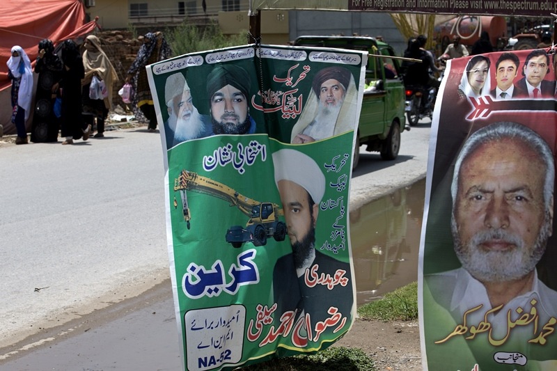 Workers from the Pakistani radical political party, Tehreek-i-Labbaik Ya Rasool Allah, hang election posters for their candidate on a roadside in Islamabad, Pakistan. Apart from Saeed's party, previously unknown radical group Tehreek-e-Labbaik Pakistan is also in the fray. Its rallies shut down parts of Islamabad earlier this year after the party accused Sharif's government of blasphemy for accidentally dropping a reference to the Prophet Muhammad from a draft law.