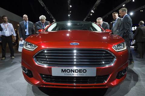 Visitors look at the new Ford Motor Co. Mondeo Titanium automobile after it was unveiled at company's "Go Further" launch event at the Ziggo Dome in Amsterdam, Netherlands, on Thursday, Sept. 6, 2012. Photographer: Jock Fistick/Bloomberg