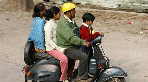 A family rides on a scooter in the northeastern Indian city of Siliguri January 11, 2008. Two wheeler prices are likely to slide and banks' car loan portfolios are set to rise from October when millions of consumers start buying the world's cheapest car made by Tata Motors, a survey said on Friday. REUTERS/Rupak De Chowdhuri (INDIA)