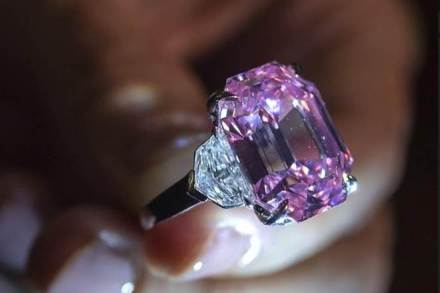 A Christie's employee displays an 18.96-carat fancy vivid pink diamond during a preview at Christie's in Geneva, Switzerland, Thursday, Nov. 8, 2018. It is estimated to sell between $30-$50 million. The auction will take place in Geneva, on Nov. 13. (Martial Trezzini/Keystone via AP)
