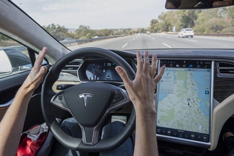 A member of the media test drives a Tesla Motors Inc. Model S car equipped with Autopilot in Palo Alto, California, U.S., on Wednesday, Oct. 14, 2015. Photographer: David Paul Morris/Bloomberg