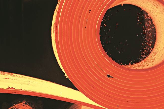 Red hot steel is fed into a hot rolled steel machine during production at a facility in Indiana, U.S. Photographer: Daniel Acker/Bloomberg