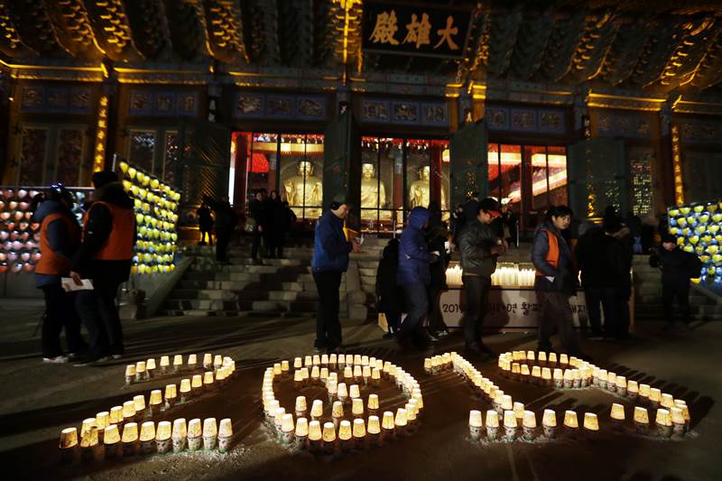 Buddhists light up candles during New Year celebrations at Jogyesa Buddhist temple in Seoul, South Korea. (AP Photo)