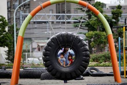Children ride on a swing made with an old tire at Nishi Rokugo Park, also known as the Tire Park, at Ota-Ku, in Tokyo, Japan (REUTERS/Kim Kyung-Hoon/File Photo)
