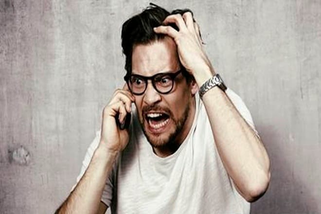 Angry young man on cell phone, studio