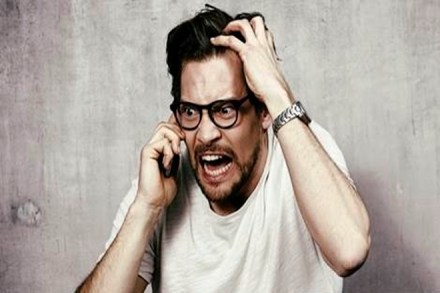 Angry young man on cell phone, studio