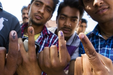 Voters displays their inked fingers for a photograph after casting their votes at a polling station in 2014. (Bloomberg Photo)