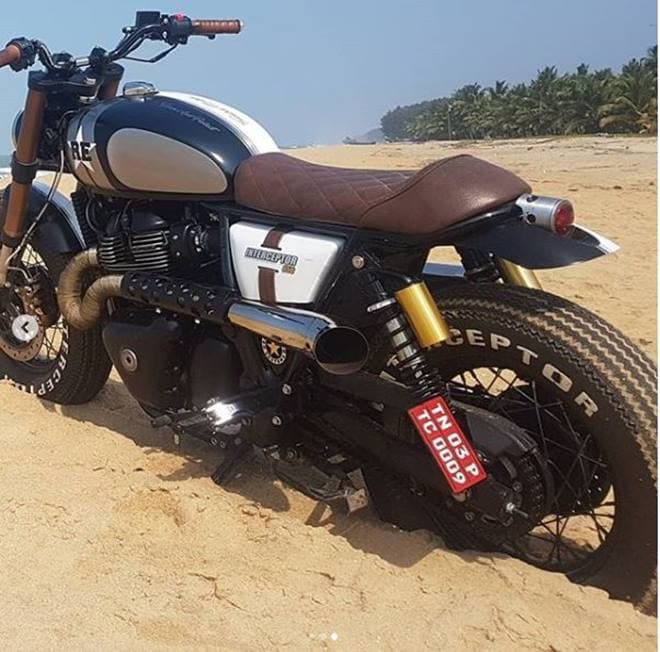 The paint job is neat and simple with contrasting shades of black and white, and the shiny chrome on the engine block has been covered in black on one side. The scrambler-style curving exhaust pipes add extensively to the bike's appeal.