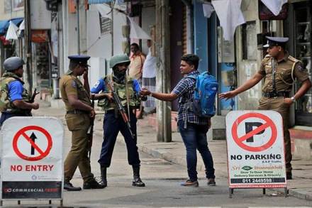 Sri Lankan policemen check the identity card of a person carrying a back-pack, in Colombo. (AP Photo via PTI)