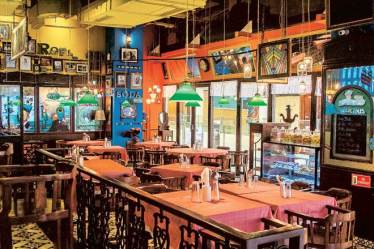 The interiors of the restaurant are a nod to Parsi homes, complete with antiques, checked tablecloths, bentwood chairs and interesting graffiti.