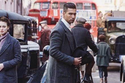 The actor sports a suave hairstyle and a wound mark on his right cheek and is dressed in an overcoat