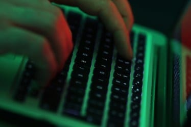 Green light illuminates the keyboard of laptop computer as a man enters the data using the computer keyboard in this arranged photograph in London, U.K. Photographer: Chris Ratcliffe/Bloomberg