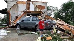 A person looks over damage to his home after a tornado struck the city (AP photo)