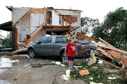 A person looks over damage to his home after a tornado struck the city (AP photo)