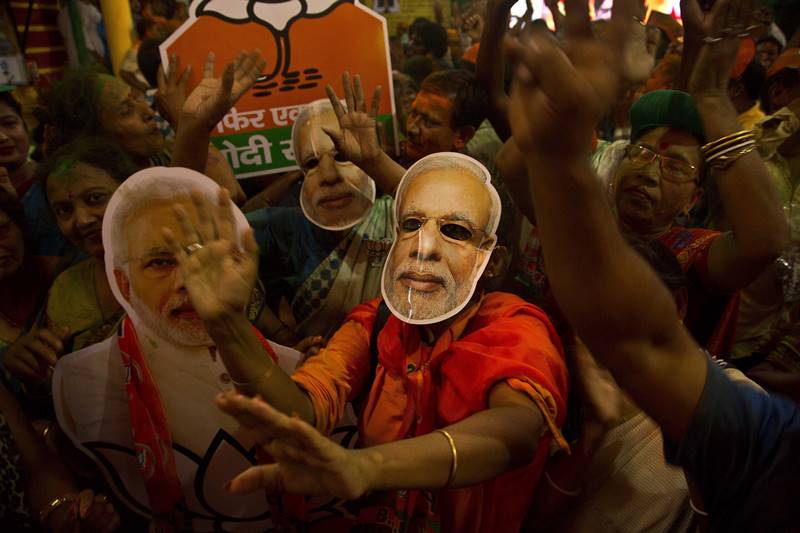In addition to these, a couple of artists drew tattoos on children's hands and painted 'Modi' over their cheeks while women supporters danced as well as rejoiced celebrating a massive majority for the saffron party. (photo: AP)