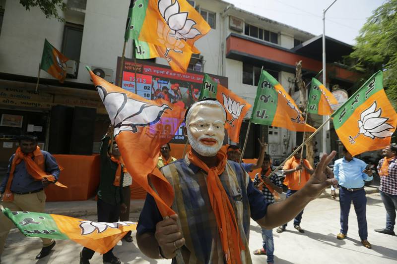 Within the headquarters, the vibrant mood was particularly festive as party supporters, who came from near and far, joined in the revelry of victory, as pictorial cut-outs of Prime Minister Narendra Modi as well as BJP President Amit Shah swayed in the air. (photo: AP)
