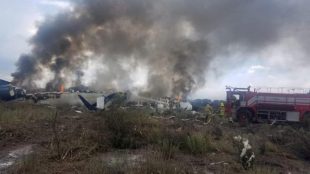 Note: This image is from Mexico's northern state of Durango, July 31, 2018, in which firefighters douse a fire as smoke billows above the site where an Aeromexico-operated Embraer passenger jet which crashed Proteccion Civil Durango/via REUTERS