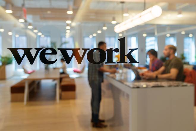 Signage is seen at the entrance of the WeWork Cos Inc. 85 Broad Street offices in the Manhattan borough of New York, U.S., on Wednesday, May 22, 2019. WeWork has become the biggest private office tenant in London, Manhattan and Washington on its way to 425 office locations in 36 countries overall. Photographer: David 'Dee' Delgado/Bloomberg