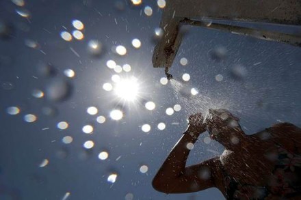 A woman stands under a shower on the beach in Nice as a heatwave hits much of France. (REUTERS) A woman stands under a shower on the beach in Nice as a heatwave hits much of France. (REUTERS)
