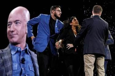 Security removes a protestor, second from left, from the stage as Amazon CEO Jeff Bezos speaks at the the Amazon re:MARS convention, Thursday. (AP Photo)