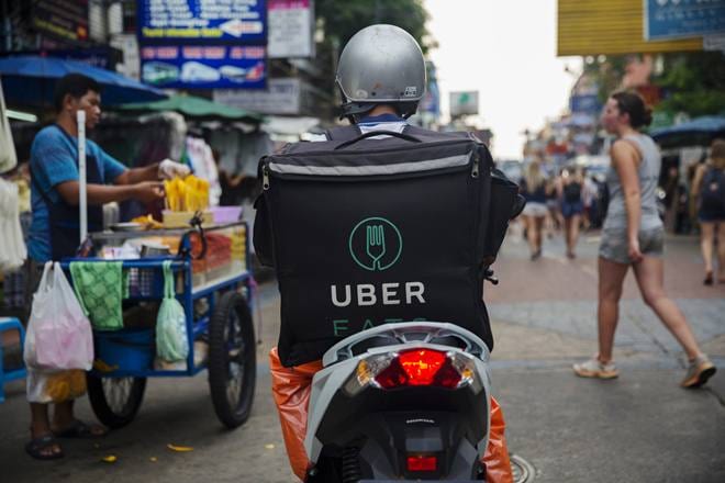 An Uber Technologies Inc. Eats delivery driver rides a motorcycle along a road in Bangkok, Thailand, on Friday, March 9, 2018. Uber Chief Executive Officer Dara Khosrowshahi said growth of the UberEats app was exploding and estimated that it would be the largest food-delivery business in the world this year. Photographer: Brent Lewin/Bloomberg