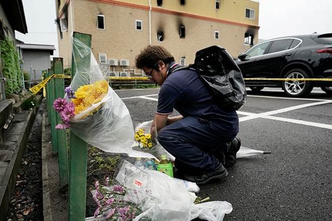 A man places flowers outside the Kyoto Animation Studio building (AP Photo)