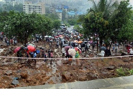 Rescue operations in progress at the site where a portion of a compound wall collapsed and many shanties were washed away due to incessant rain, in Pimpripada of Malad East, Mumbai. (PTI Photo