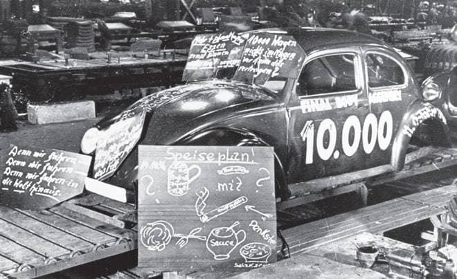 Fast forward to 1945. The war is over, the world is relieved as Germany falls to the Allied Forces and the Volkswagen factory lying in ruins is set to roll out a civilian model. The Wolfsburg plant was hit by ongoing repairs, material shortages, and not having an owner. The Allied government put Major Ivan Hirst in charge and the factory was restored to full service with an order for 20,000 VWs for the occupation forces. Pictured here is the assembly of the 10,000th Bug.