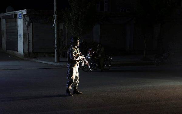 An Afghan police man stand guard outside the wedding hall after an explosion in Kabul (AP Photo)