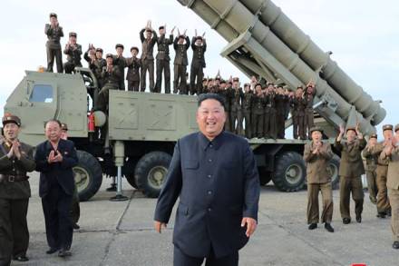 North Korean leader Kim Jong Un, center, smiles after the test firing of an unspecified missile at an undisclosed location in North Korea (Korean Central News Agency/Korea News Service via AP)