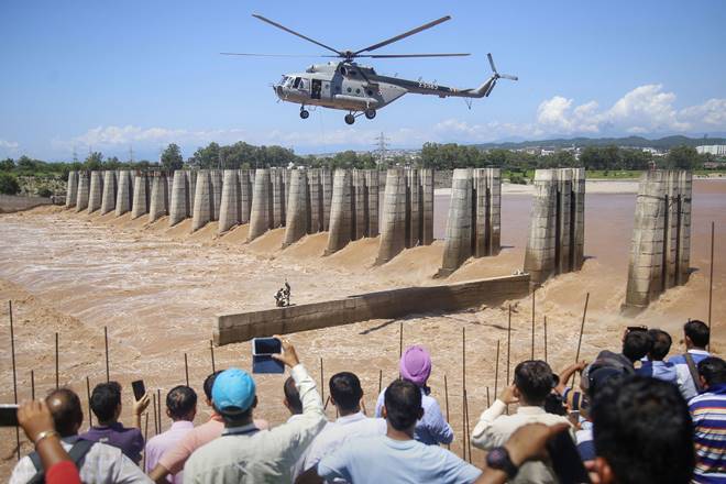 A chopper of the Indian Air Force approaches to airlift two persons stuck on an under-construction bridge at the flooded Tawi river in Jammu. (PTI Photo)