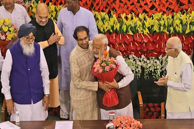 Prime Minister Narendra Modi, center, hugs Shiv Sena party chief Uddhav Thackeray after being elected as Bharatiya Jananta Party and ruling alliance leader, in New Delhi