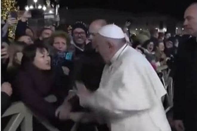The 83-year-old pope grimaced and scowled before managing to break free, slapping her hand twice as a security guard intervened. (Source: Screengrab) The 83-year-old pope grimaced and scowled before managing to break free, slapping her hand twice as a security guard intervened. (Source: Screengrab)
