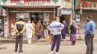 People stand outside a pharmacy to buy medicines during a nationwide lockdown, imposed in the wake of coronavirus pandemic, in Jammu (PTI photo)