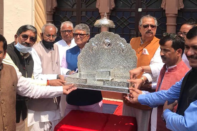 Descendant of the erstwhile royal family of Ayodhya, Bimlendra Mohan Mishra, hands over a silver throne for Ram Lalla to the trust on Monday. 