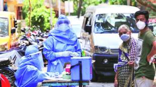 Health workers collect throat swabs for Covid-19 test from residents of a colony in Mahim, Mumbai (Express photo)