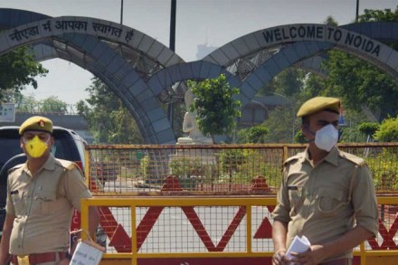 Policemen stand near barricades to check vehicles crossing the sealed Delhi-Noida border. (PTI Photo. File)