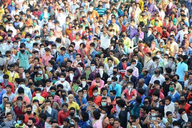 Daily wage earners, numbering around 1,000, assembled at suburban Bandra (West) bus depot near the railway station and squatted on road at around 3 pm. (Photo: PTI)
