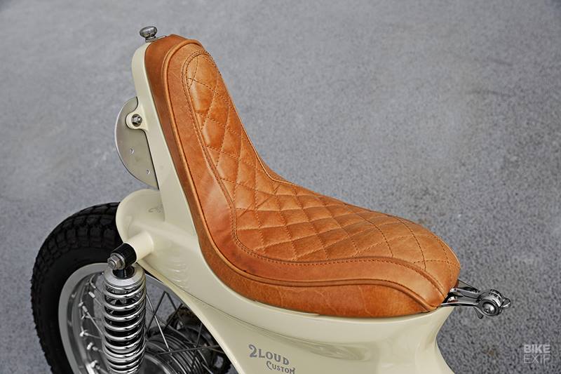 A pair of LED turn signals are embedded into the sides of the swing arm. With the scoot’s original side panels gone too, Max and Lu had a couple of holes to fill on the sides of the bike. So they fabricated a pair of 3D heart-shaped covers to fill in the gaps. (Source: Bikeexif)