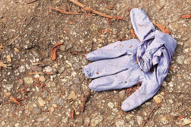 A blue protective glove that has been thrown away.